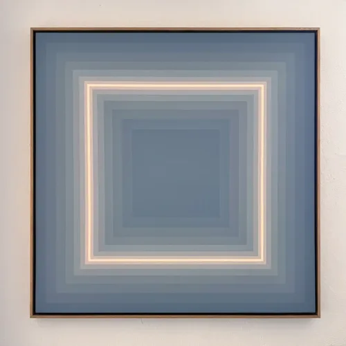 "Ignite" – a geometric abstract painting featuring a structured gradient transitioning from deep grey to a bold fluorescent orange glow. The piece is framed in a minimalist wooden frame and displayed against a neutral wall, emphasizing its striking contrast and depth.